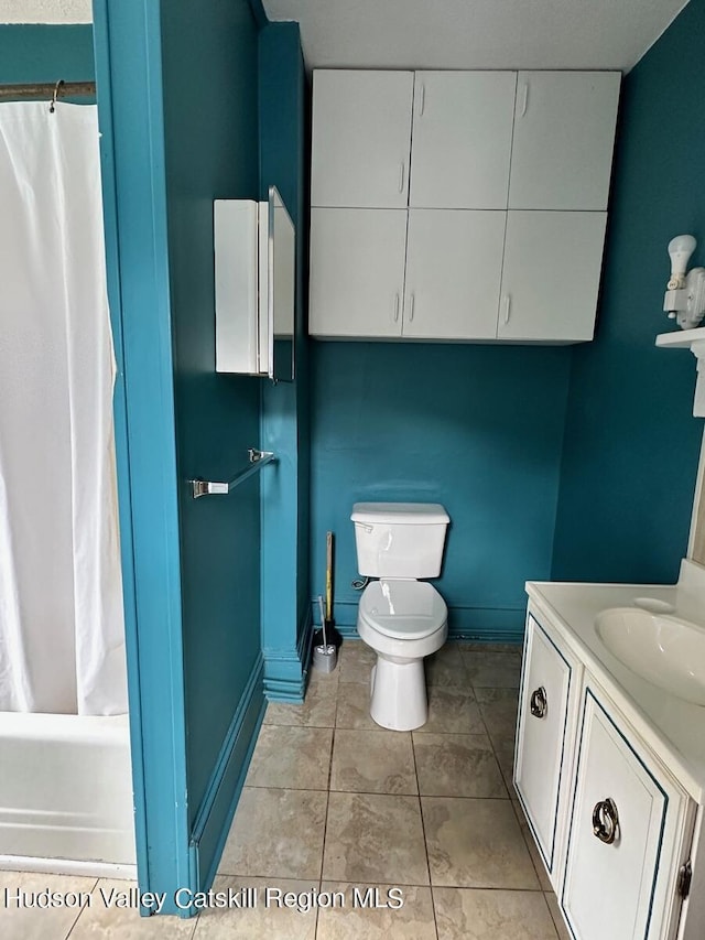 bathroom featuring shower / tub combo, baseboards, toilet, tile patterned flooring, and vanity