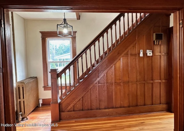 stairs with wood-type flooring and radiator