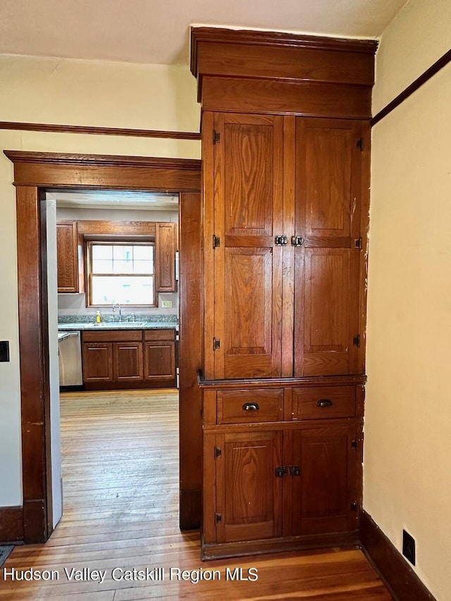 hall with light hardwood / wood-style flooring and sink