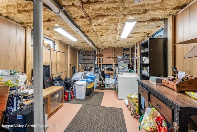 basement with wood walls and electric panel