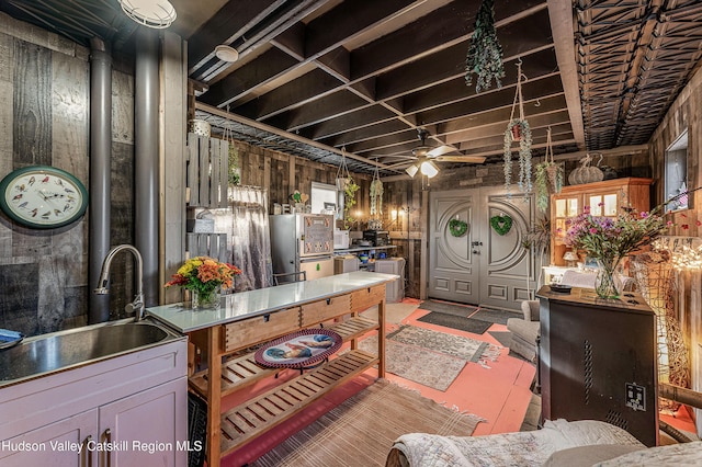 interior space with ceiling fan, stainless steel fridge, and sink