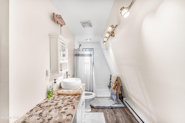 bathroom featuring walk in shower, sink, wood-type flooring, a baseboard radiator, and toilet