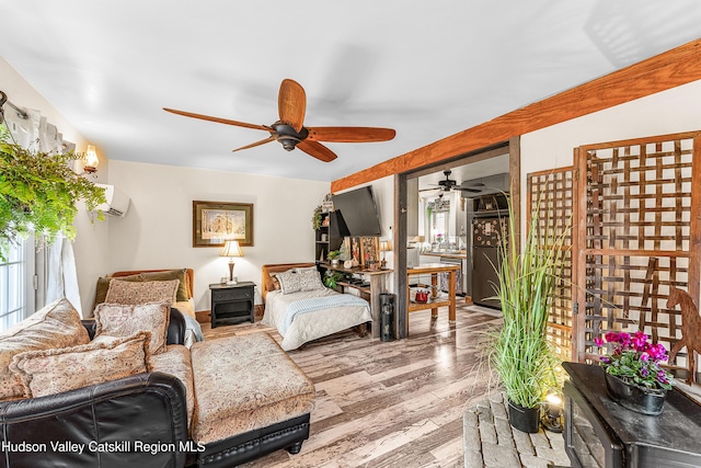 bedroom featuring wood-type flooring, a wall unit AC, and ceiling fan