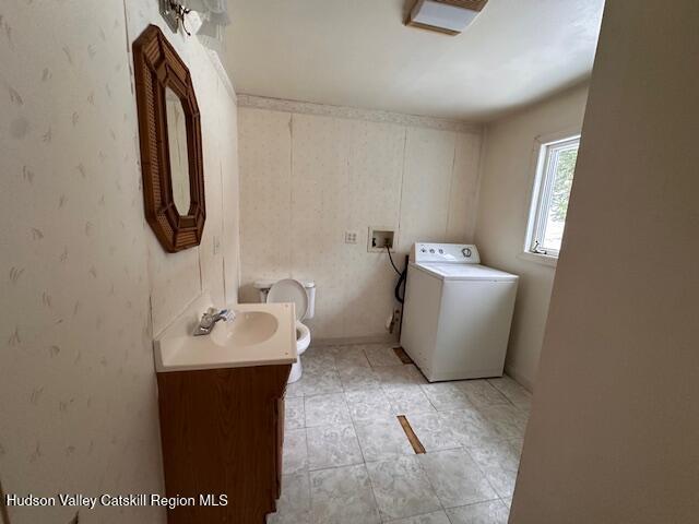 bathroom with washer / dryer, toilet, and vanity