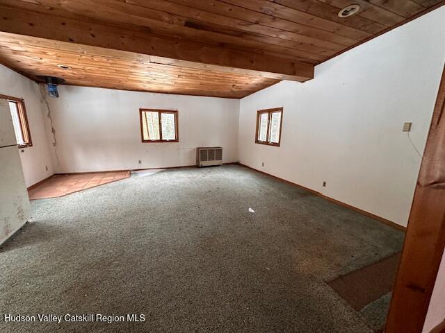 unfurnished room featuring beam ceiling, wood ceiling, and carpet flooring