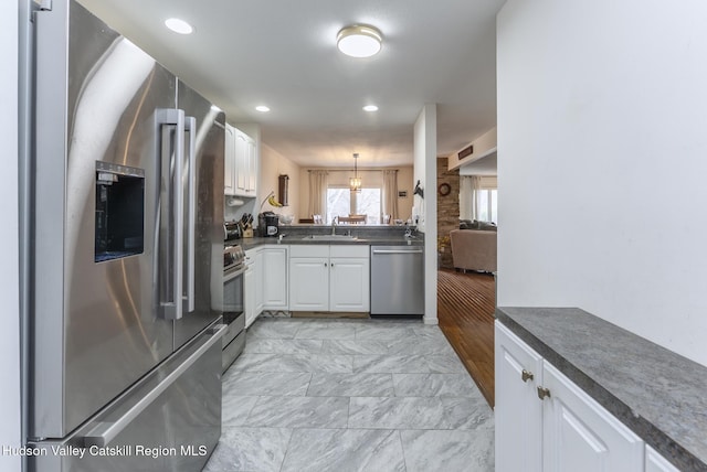 217 Aspen Ter, Poughkeepsie, NY 12601 - kitchen featuring a sink, stainless steel appliances, marble finish floor, white cabinets, and dark countertops