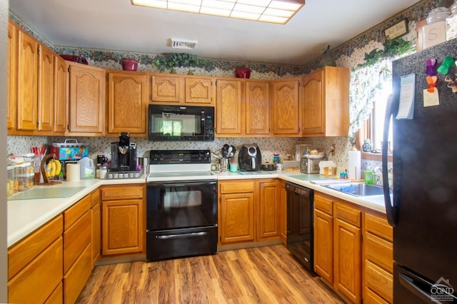 1859 Spruce Ln, Castleton, NY 12033 - kitchen featuring black appliances, light wood-type flooring, a sink, light countertops, and brown cabinets