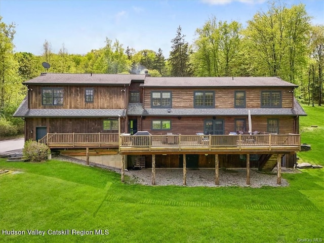 back of house featuring a lawn and a wooden deck