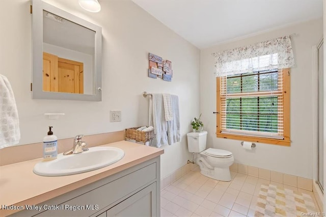 bathroom with tile patterned floors, a shower with door, vanity, and toilet