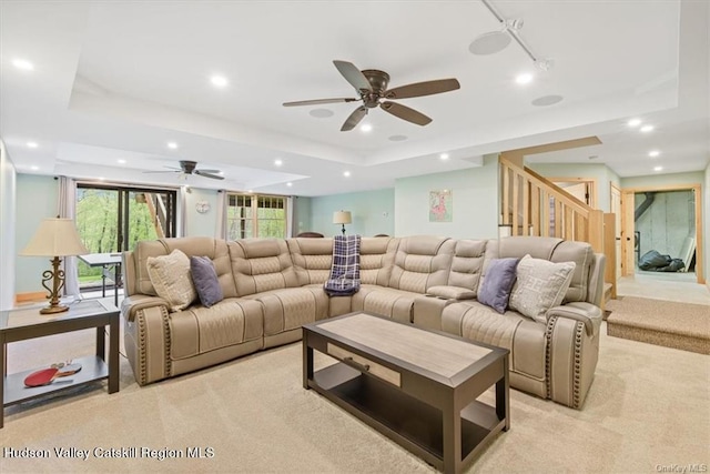 home theater room featuring a tray ceiling, ceiling fan, and light colored carpet