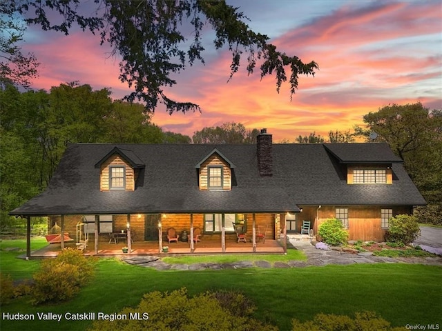 back house at dusk with a yard and a patio