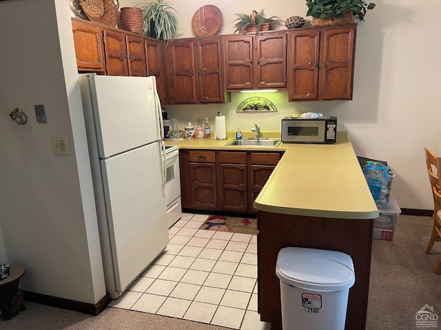 26 Townhouse Ln Unit 4A, Windham, NY 12496 - kitchen with white appliances, a sink, a peninsula, light countertops, and baseboards