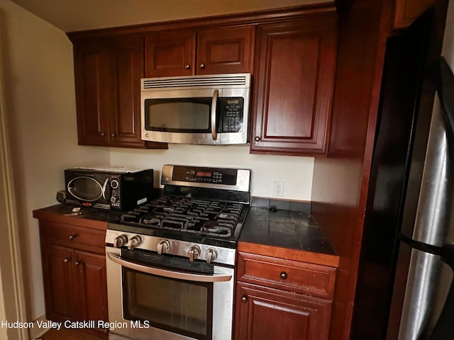 kitchen with dark countertops, a toaster, and appliances with stainless steel finishes