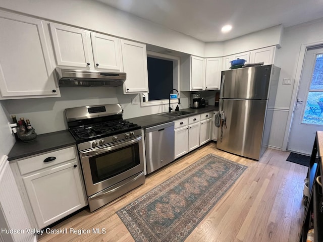 kitchen featuring light wood-type flooring, stainless steel appliances, sink, and white cabinets