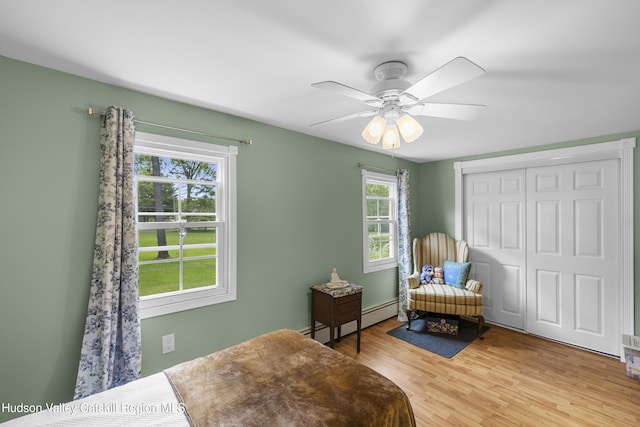 2410 Bruynswick Rd, Wallkill, NY 12589 - bedroom featuring a baseboard heating unit, light wood-style floors, a closet, and ceiling fan