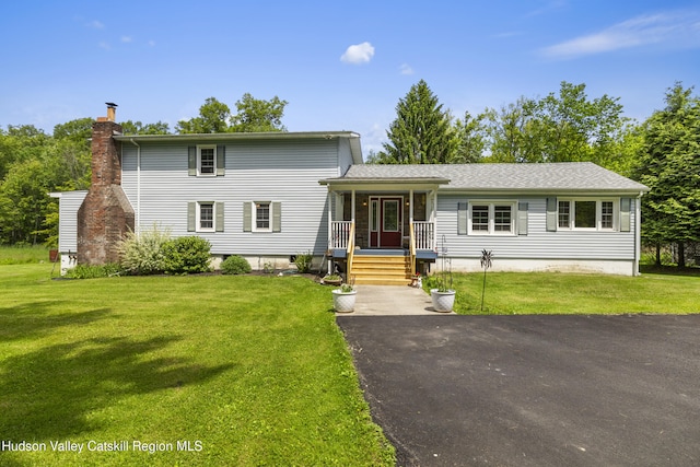 2410 Bruynswick Rd, Wallkill, NY 12589 - view of front of home featuring a chimney, a front yard, and covered porch