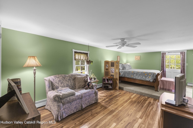 2410 Bruynswick Rd, Wallkill, NY 12589 - bedroom featuring a baseboard heating unit, wood finished floors, and a ceiling fan