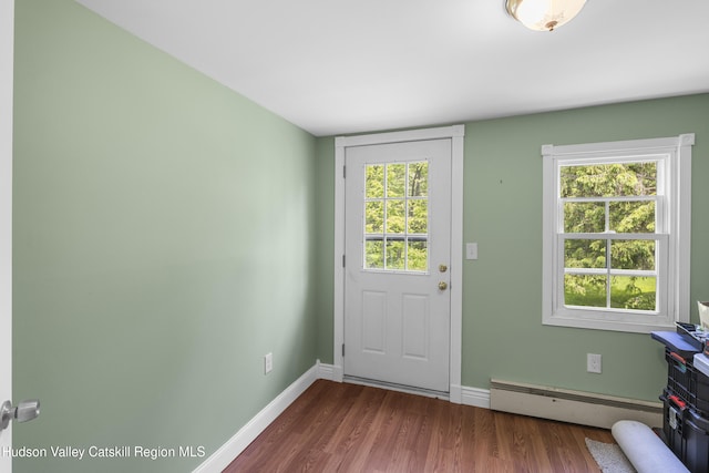 2410 Bruynswick Rd, Wallkill, NY 12589 - doorway to outside featuring a baseboard radiator, dark wood-type flooring, baseboards, and healthy amount of natural light