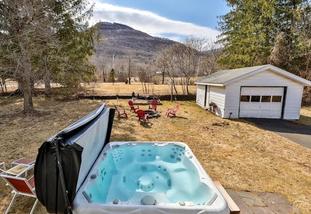 51 Division St, Hunter, NY 12442 - view of yard with a detached garage, a mountain view, an outdoor structure, asphalt driveway, and a hot tub