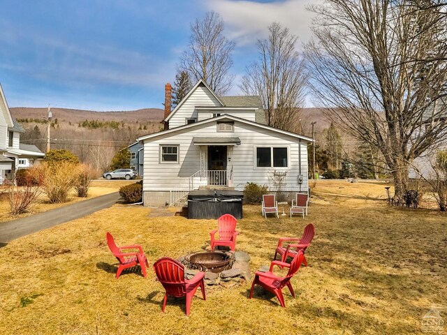 51 Division St, Hunter, NY 12442 - view of front of home with an outdoor fire pit, a chimney, a front lawn, and a mountain view