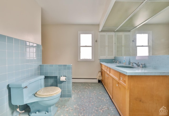 51 Division St, Hunter, NY 12442 - bathroom featuring baseboard heating, tile walls, toilet, plenty of natural light, and double vanity