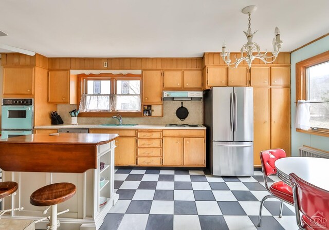 51 Division St, Hunter, NY 12442 - kitchen with freestanding refrigerator, a sink, a chandelier, light countertops, and under cabinet range hood