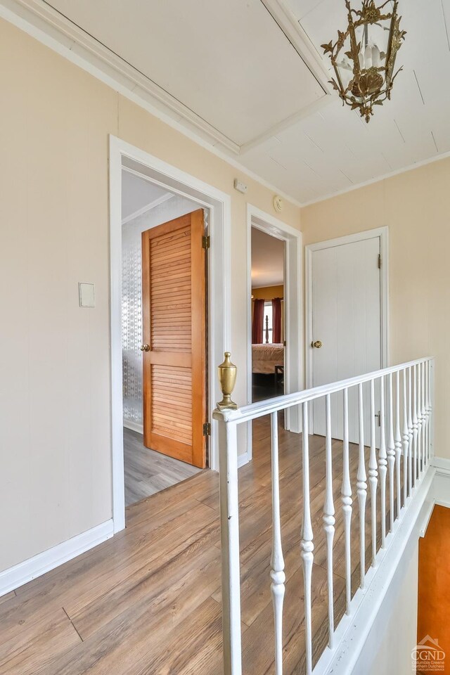 51 Division St, Hunter, NY 12442 - hall featuring wood finished floors, baseboards, an upstairs landing, and ornamental molding