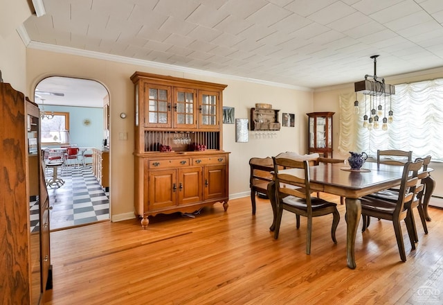 51 Division St, Hunter, NY 12442 - dining area with arched walkways, light wood-style floors, crown molding, and baseboards