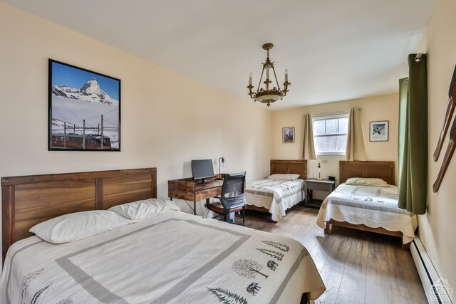 51 Division St, Hunter, NY 12442 - bedroom featuring a baseboard heating unit, wood finished floors, and a chandelier
