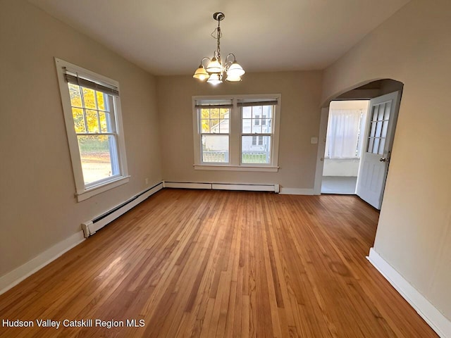 unfurnished dining area featuring an inviting chandelier, wood-type flooring, and a baseboard heating unit