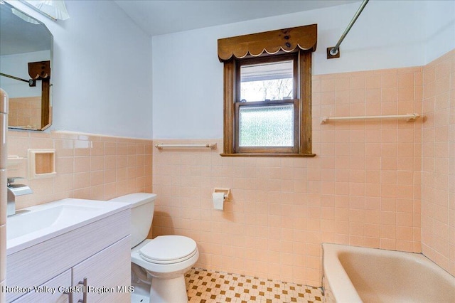 bathroom with tile patterned floors, vanity, toilet, and tile walls