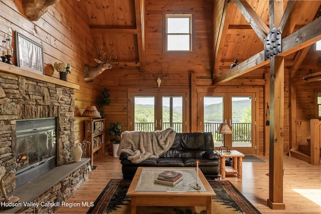 422 Waterview Dr, Andes, NY 13731 - living area featuring french doors, wood walls, high vaulted ceiling, healthy amount of natural light, and wood finished floors