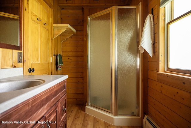 422 Waterview Dr, Andes, NY 13731 - bathroom featuring wooden walls, a stall shower, vanity, wood finished floors, and baseboard heating