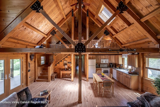 422 Waterview Dr, Andes, NY 13731 - living area featuring wood walls, light wood-style floors, high vaulted ceiling, stairway, and wood ceiling with exposed beams