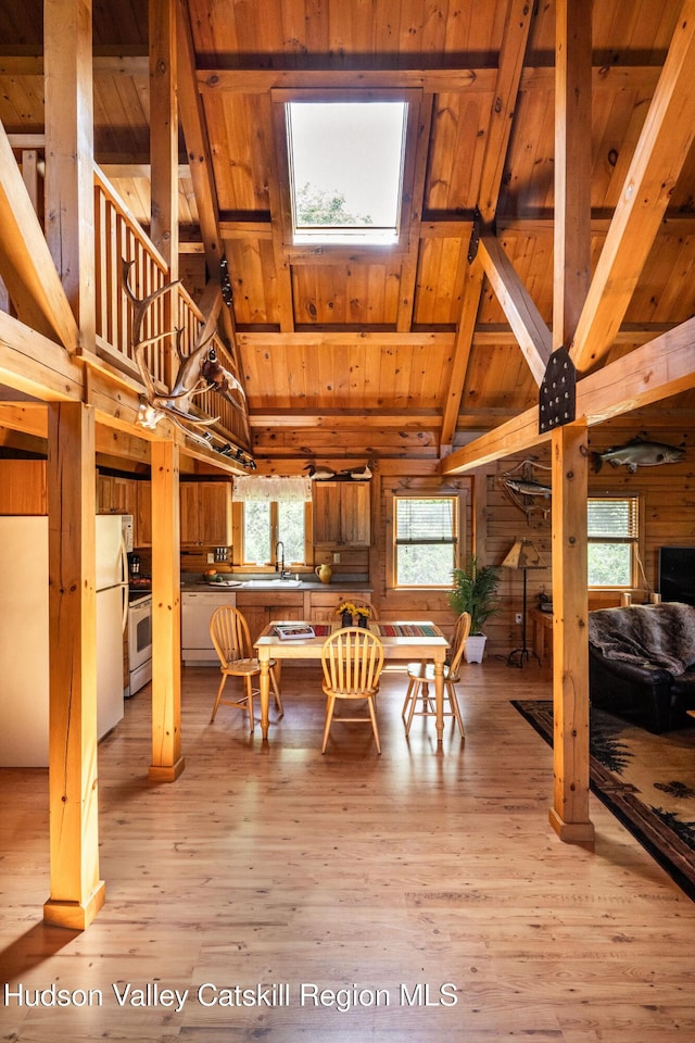 422 Waterview Dr, Andes, NY 13731 - dining room featuring wooden ceiling with exposed beams, wood walls, a skylight, healthy amount of natural light, and light wood-type flooring