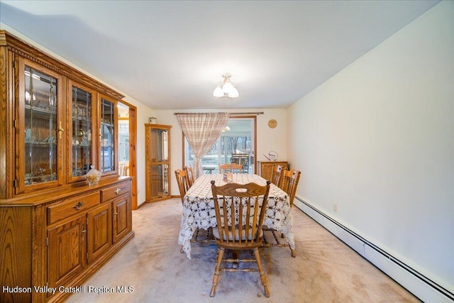 dining area with a baseboard heating unit and light colored carpet