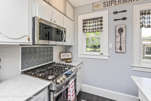 71 Melrose Ave, Albany, NY 12203 - kitchen featuring appliances with stainless steel finishes, decorative backsplash, baseboards, white cabinets, and dark wood-style floors