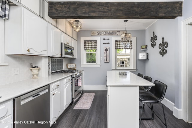 71 Melrose Ave, Albany, NY 12203 - kitchen with appliances with stainless steel finishes, baseboards, white cabinetry, dark wood-style flooring, and a kitchen island