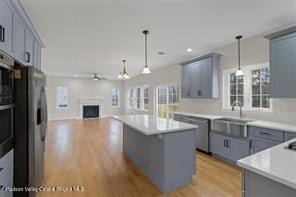 kitchen featuring appliances with stainless steel finishes, a center island, decorative light fixtures, and plenty of natural light