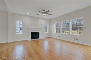 unfurnished living room featuring ceiling fan, a healthy amount of sunlight, and light hardwood / wood-style flooring