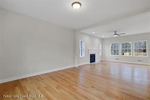 unfurnished living room with ceiling fan, light hardwood / wood-style floors, and a wealth of natural light