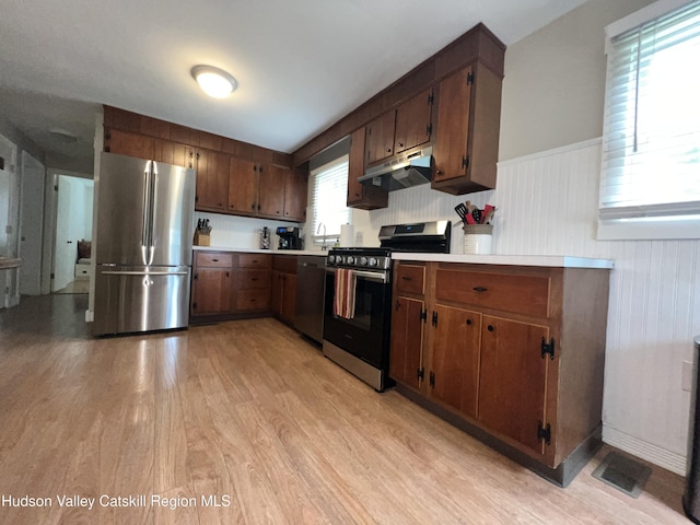 14 Brown Rd, Copake, NY 12516 - kitchen with stainless steel appliances, light wood-style floors, under cabinet range hood, light countertops, and a wainscoted wall