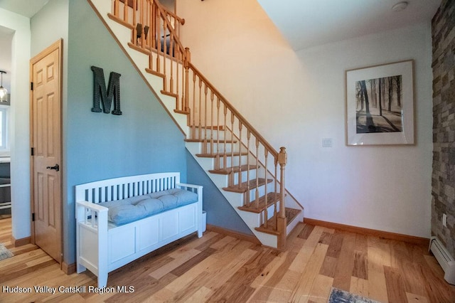 stairway featuring hardwood / wood-style flooring and baseboard heating