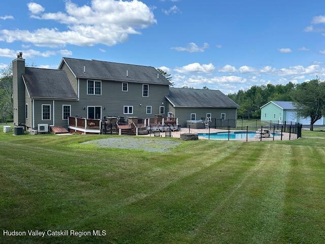 back of house with a lawn and a swimming pool side deck