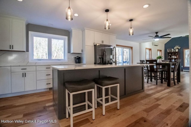 kitchen featuring white cabinets, a center island, and a wealth of natural light