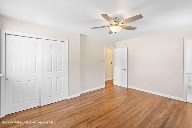 unfurnished bedroom with ensuite bath, wood-type flooring, a closet, and ceiling fan