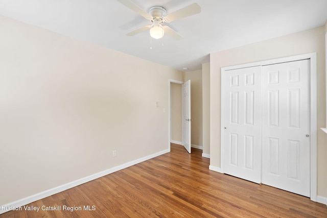 unfurnished bedroom featuring wood-type flooring, a closet, and ceiling fan