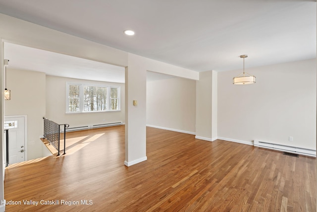 interior space with a baseboard radiator and hardwood / wood-style floors