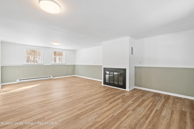 unfurnished living room featuring hardwood / wood-style floors, a baseboard radiator, and a multi sided fireplace