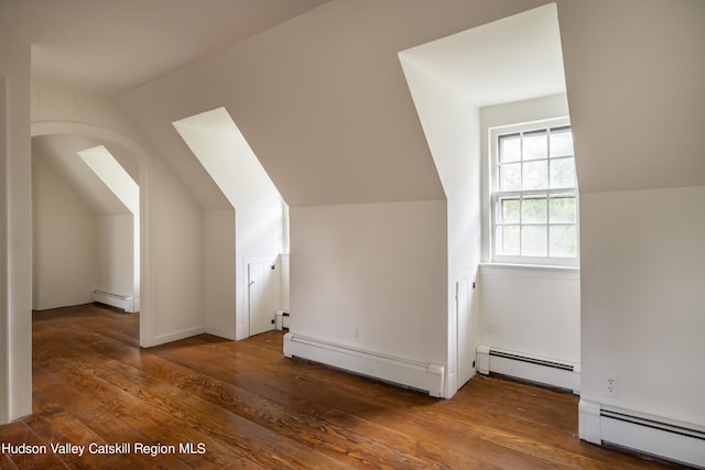 additional living space with dark hardwood / wood-style flooring and a baseboard heating unit